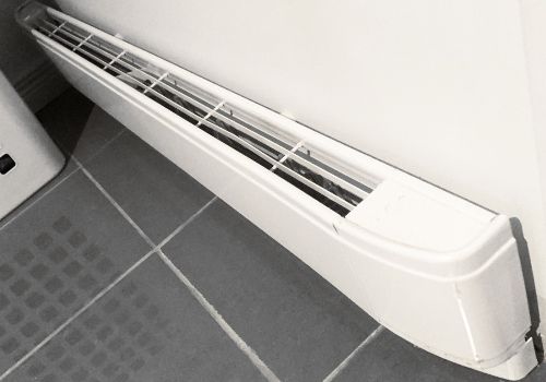 Baseboard Heater Installation Services - DK Electrical Solutions Inc. Woman Baseboard Heater - Electrician in Southampton, NJ